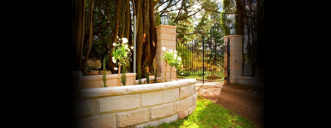 Sandstone achieves a grand curved boundary fence coupled with a complementary classical style wrought iron fence