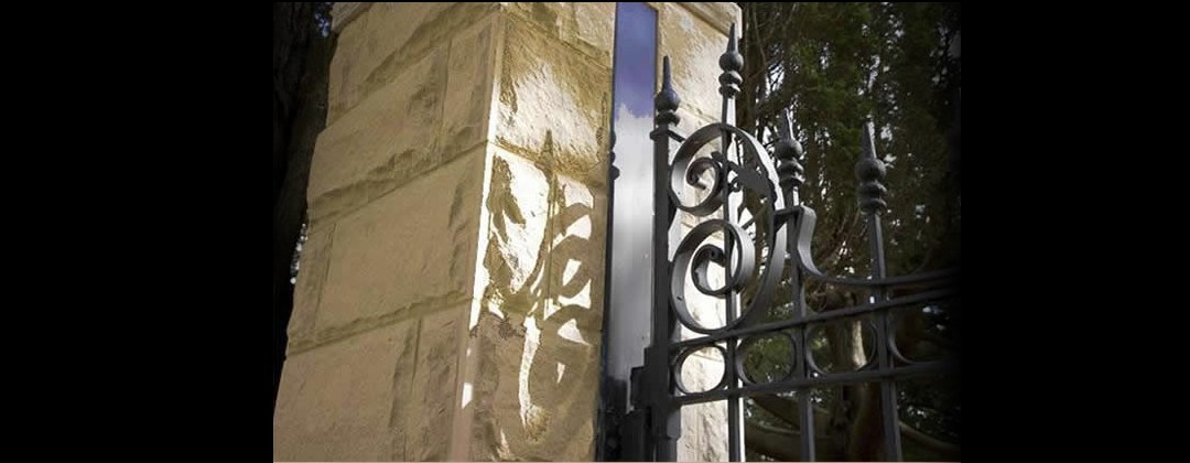 Sandstone gate pylon coupled with a complementary classical style wrought iron fence