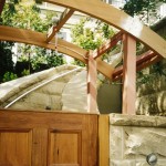 Sandstone has been used to provide a curved stairway entrance and high fencing with a timber gate.