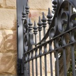 Classical wrought iron gate inset into the supporting sandstone pylon